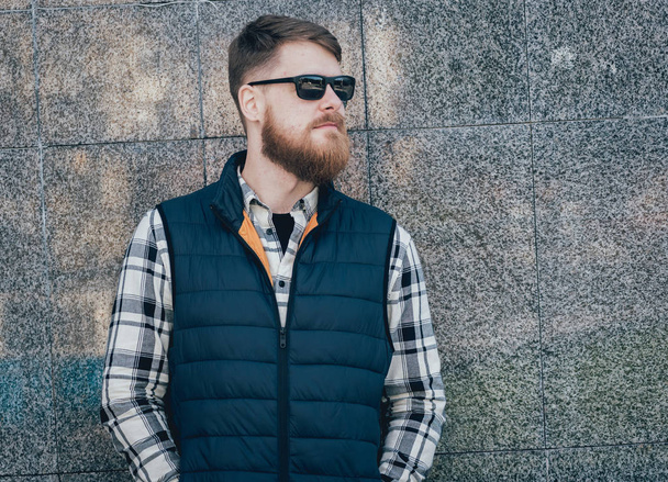 Handsome bearded man in casual clothes posing on camera outdoors - Фото, зображення