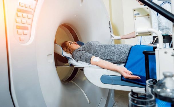Attrezzature mediche. Maschio medico caucasico e paziente femminile in camera di tomografia computerizzata in ospedale
. - Foto, immagini