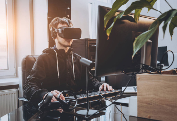 Young man in virtual reality headset in office - Foto, Bild
