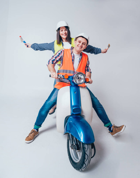 Happy young couple on motorbike. Shopping for the construction and repair for new home concept. - Фото, изображение