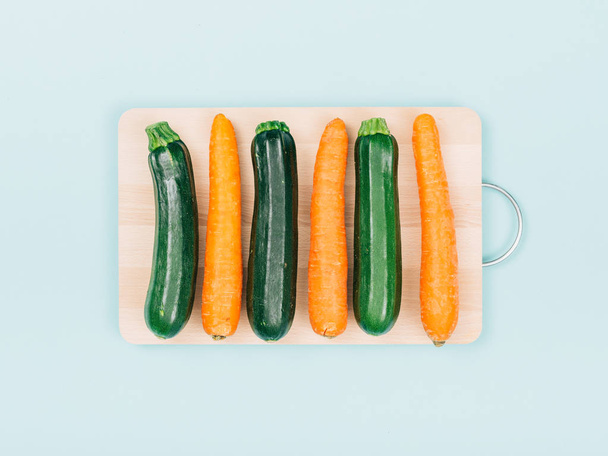 Carrots and zucchini on a wooden chopping board, food preparation and healthy eating concept - Foto, Imagen