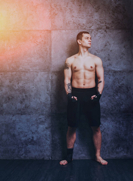 Young fighter posing in studio before grey wall - Fotografie, Obrázek