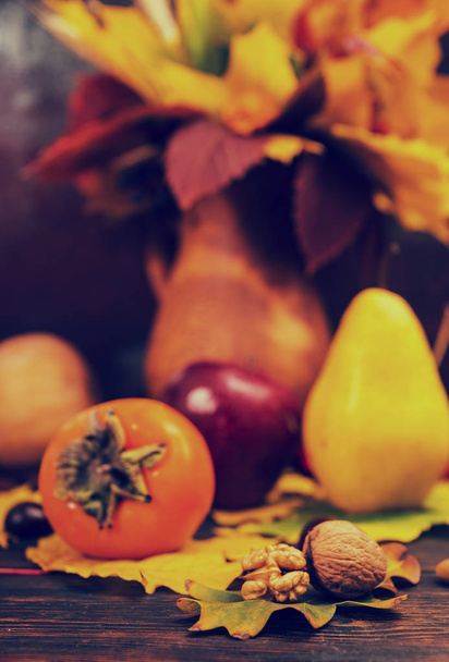 Осенний натюрморт урожая и грецкие орехи лежат на листьях деревьев на
 - Фото, изображение