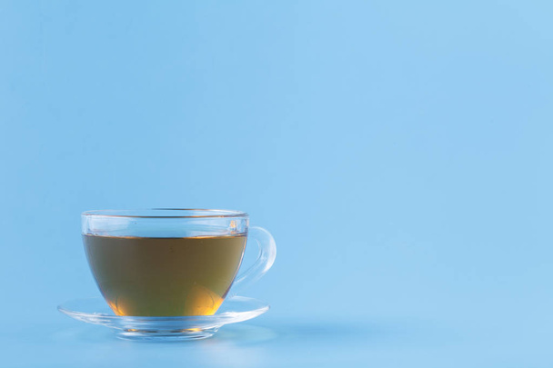Glass cup with herbal tea on blue background - Fotoğraf, Görsel