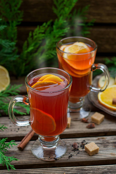 Warme vruchten thee met sinaasappel, appel, citroen, rozijnen en kruiden - Foto, afbeelding
