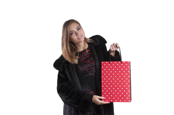 krásná dívka v černém kožichu s balíčkem pro nakupování izolované portrét - Fotografie, Obrázek