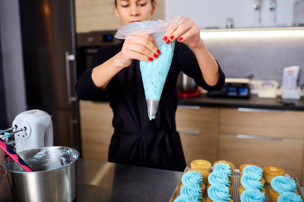 El pastelero con una bolsa de crema en las manos en el
 - Foto, Imagen