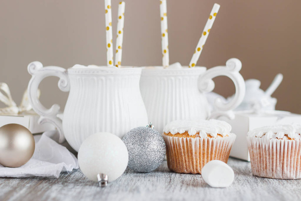 Cups with cacao and marshmallow, cupcakes and different Christmas decorations - Photo, Image