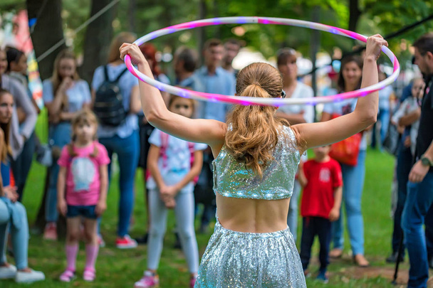 Mädchen in schönem Kleid tritt mit Hula-Hoop-Reifen auf - Foto, Bild