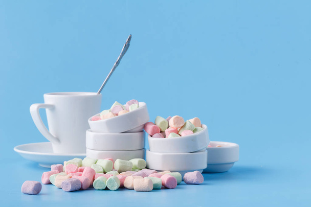 Pile of small colorfull marshmallow on blue background in bowl - Fotografie, Obrázek