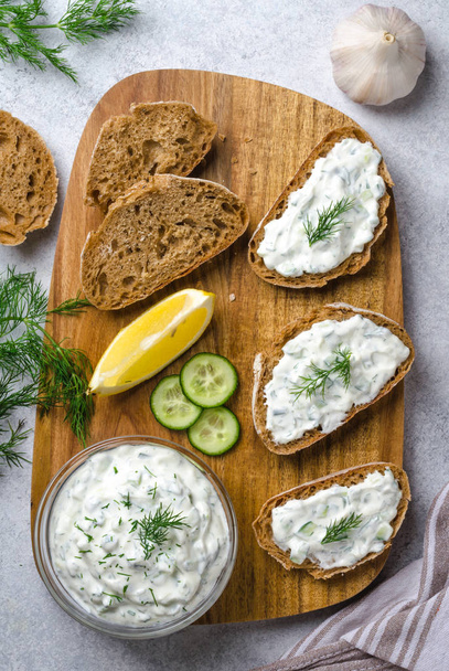 Homemade greek tzatziki sauce in a glass bowl with ingredients a - Photo, image