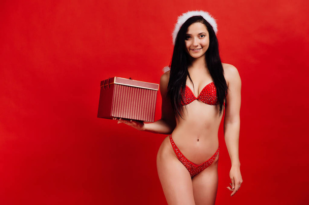 Boże Narodzenie, nowy rok wakacje... Sexy sportowe piękna dziewczyna w bikini Mikołaja z pudełko - Zdjęcie, obraz