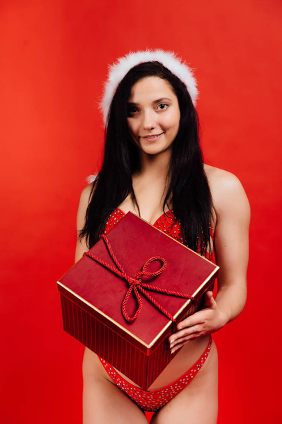 Christmas, New Years holidays.. Sexy sports beautiful girl in bikini santa claus with gift box - Фото, зображення