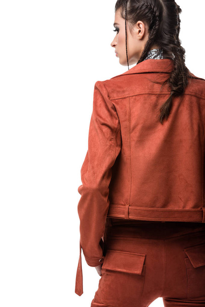 Portrait of young lady standing from back in light brown suede jacket and trousers on white background - Photo, image