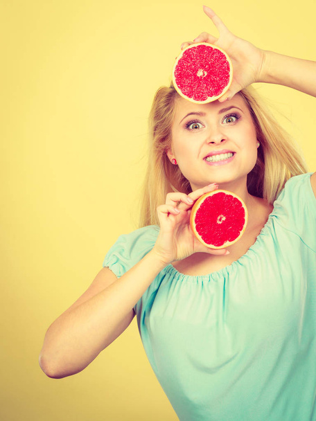 Happy smiling woman holding red grapefruit - Fotó, kép