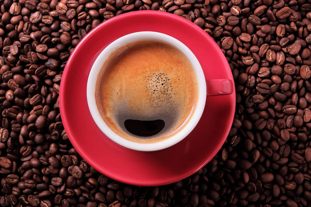 Tazza di caffè rosso con caffè espresso e fagioli tostati primo piano
 - Foto, immagini