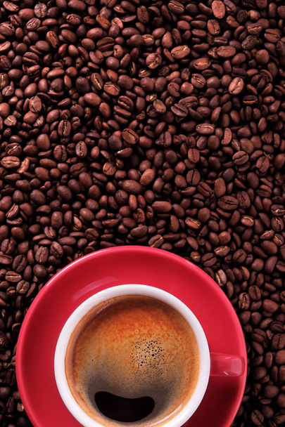 Taza de café rojo con café expreso y frijoles tostados verticales
 - Foto, imagen
