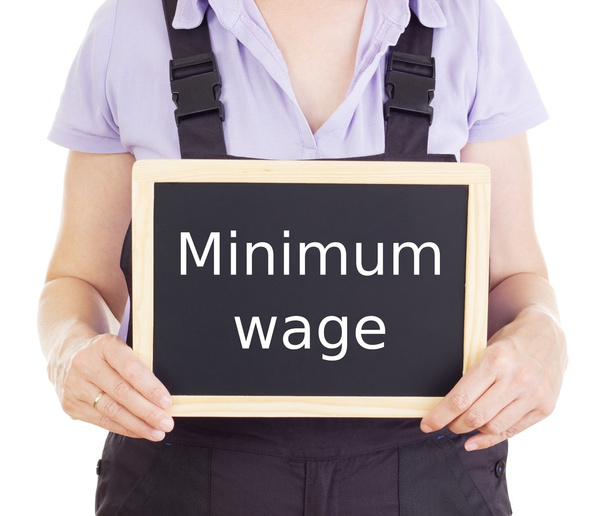 Craftsperson with blackboard: minimum wage - Photo, Image