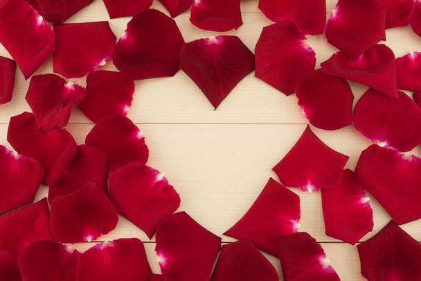 Espacio en forma de corazón decorado con pétalos de rosa roja
 - Foto, imagen
