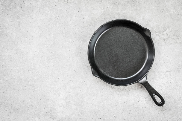 Iron pan on black stone background - Фото, изображение