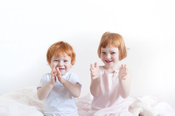 Red-haired brother and sister playing on the bed - Zdjęcie, obraz