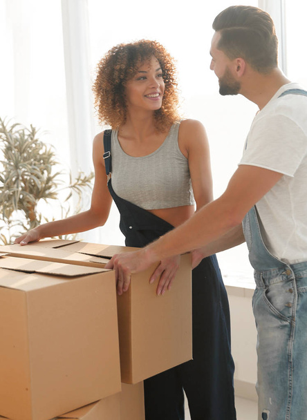Newlyweds carry boxes in a new apartment. - Photo, image