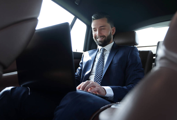 Businessman working on his laptop while sitting in the car - Foto, Bild