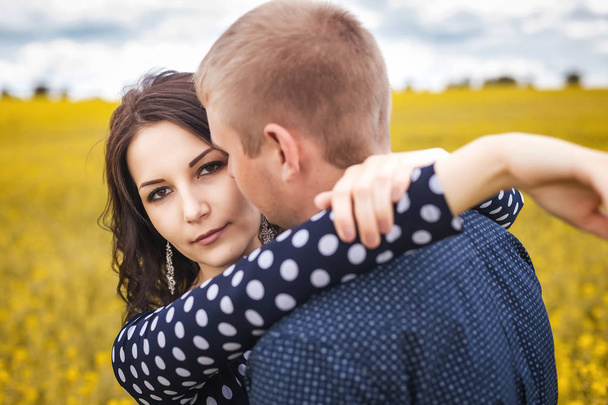 girl and boy hugging on yellow meadow - Fotó, kép