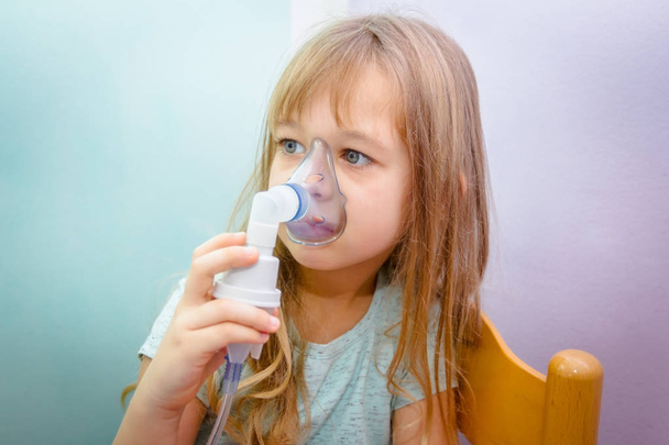 Πορτρέτο του γλυκό κοριτσάκι χρησιμοποιώντας μια συσκευή εισπνοής  - Φωτογραφία, εικόνα
