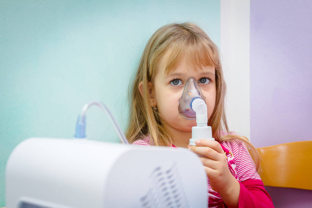 Porträt eines süßen kleinen Mädchens mit einem Inhalator  - Foto, Bild