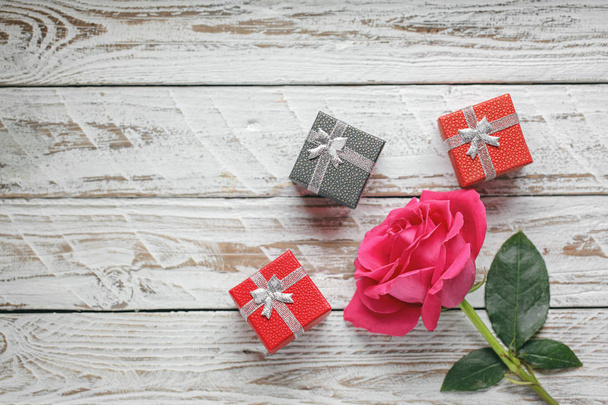 One big Rose with gift boxes on white wooden background. Love symbol concept. - Φωτογραφία, εικόνα