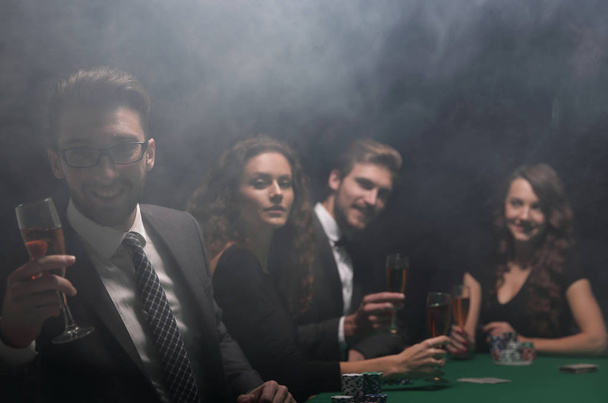 poker players with a glass of wine ,sitting at a table - Foto, imagen