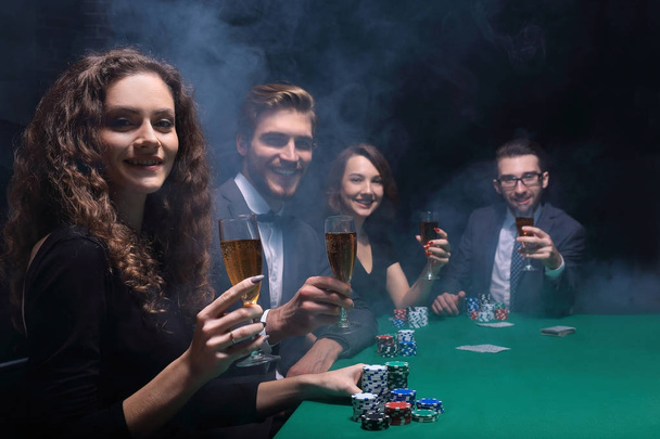 group of friends sitting at game table in casino - Foto, imagen