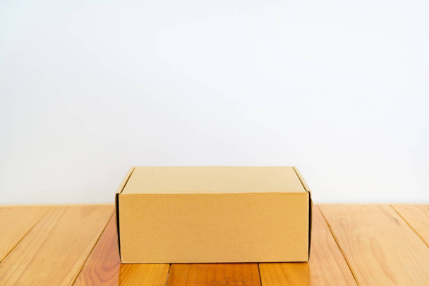 Empty brown cardboard box on wooden table with copy space. - Zdjęcie, obraz