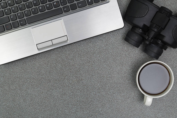 Laptop computer or notebook, binocular and cup of coffee on work - Photo, Image