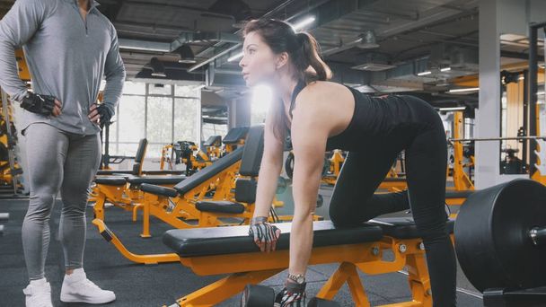 Athlète femme soulevant des haltères dans la salle de gym - gros plan
 - Photo, image