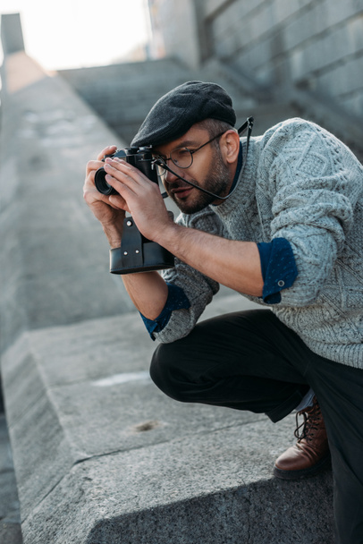 handsome adult  man taking photo with vintage film camera outdoors - Photo, Image