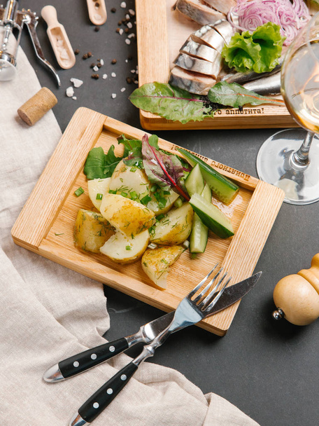 pohled shora na pečené brambory se zeleninou, podávané na dřevěném prkénku  - Fotografie, Obrázek