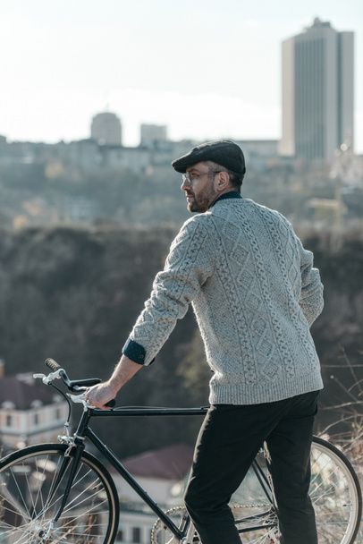 stylish adult man with vintage bicycle on sunny day - Фото, изображение