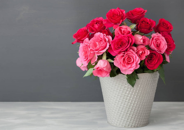 красивий букет червоних троянд у вазі над сірим
 - Фото, зображення