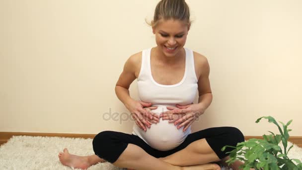 Pregnant female with little daughter touching her belly and doing heart shape with hands. - Materiał filmowy, wideo
