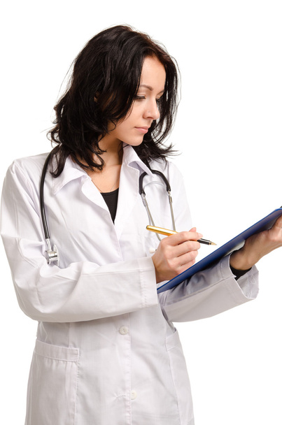 Busy young doctor writing on a clipboard - Photo, image