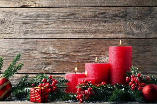 Christmas candles with fir-tree branches and red berries on wooden table - Φωτογραφία, εικόνα