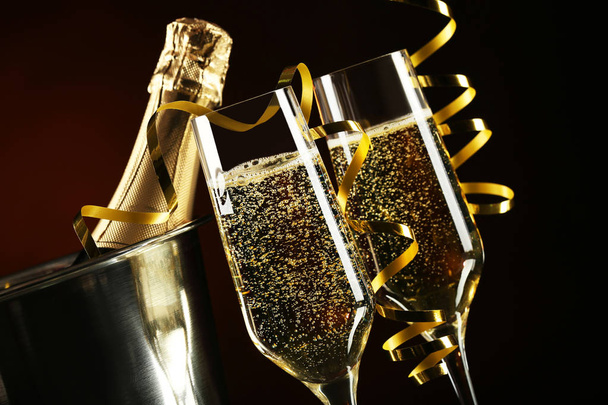 Champagne bottle in bucket with glasses on black background - Φωτογραφία, εικόνα