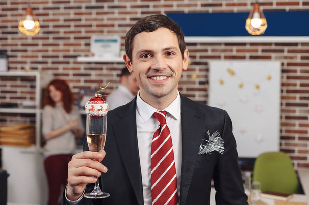 Hombre de negocios sonriente sosteniendo una copa con champán
 - Foto, imagen