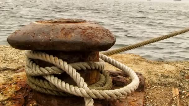 viejo pilona oxidada con la cuerda de fijación del barco en el muelle en el puerto
 - Imágenes, Vídeo
