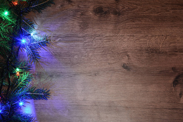 Guirnalda eléctrica de año nuevo sobre un fondo de madera. Bombillas brillantes o
 - Foto, Imagen