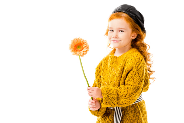 sonriente pelo rojo niño sosteniendo flor aislado en blanco
  - Foto, imagen