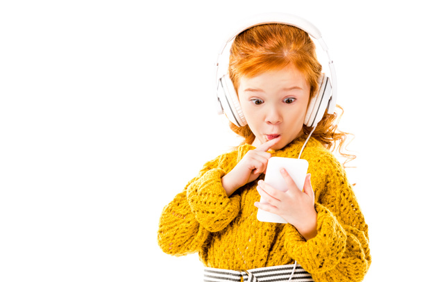 Kızıl saçlı çocuk üzerinde beyaz izole smartphone ile sürpriz bakarak - Fotoğraf, Görsel