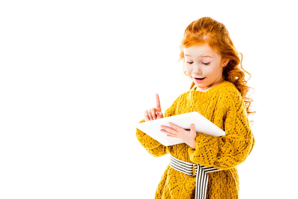 Vöröshajú gyerek mutatja ötlet gesztus és látszó-on tabletta elszigetelt fehér - Fotó, kép